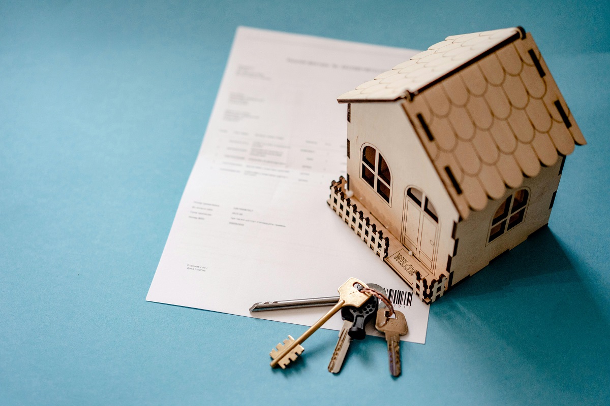 miniature house and house keys on a document